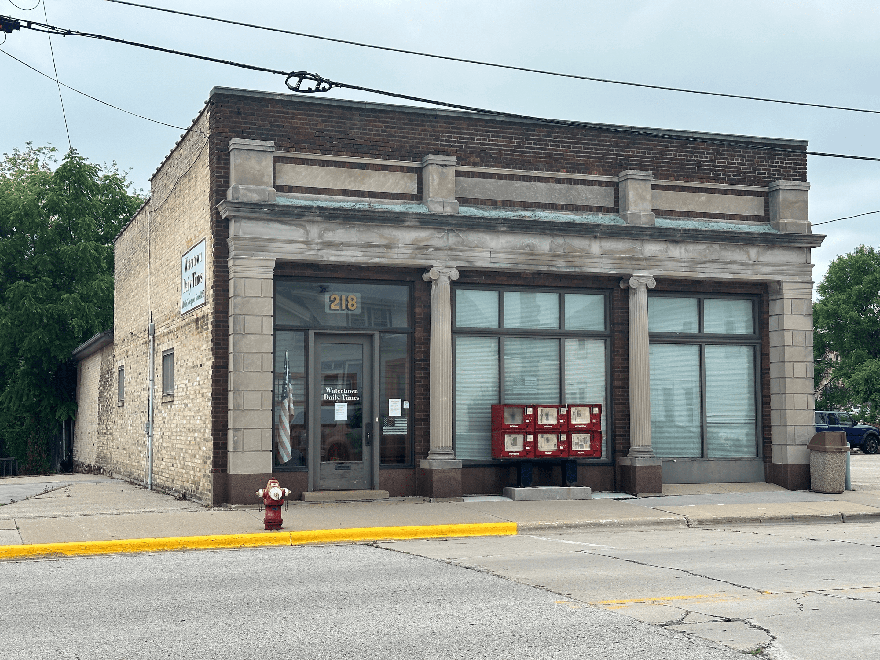 A fire hydrant in front of an old building.