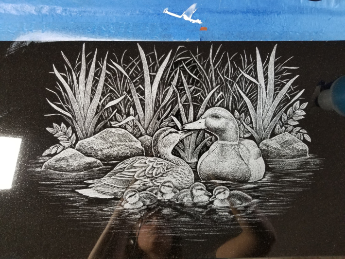 A drawing of ducks in the water with grass.